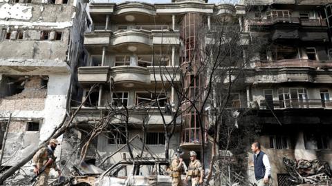 Afghan security forces inspect the site of Sunday"s attack in Kabul, Afghanistan