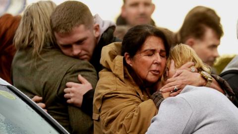 People hugs each other a at a vigil in Milford in County Donegal