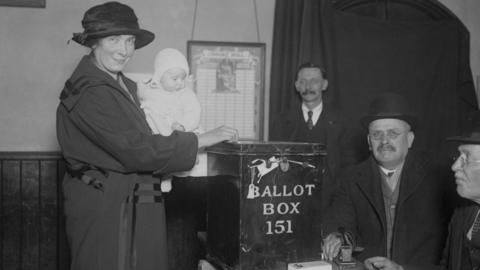 A mother casts her vote in the 1923 election