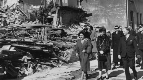 Queen Elizabeth (later Queen Mother, 1900 - 2002, left) inspecting air-raid damage in Plymouth during the Blitz, 21st March 1941. With the Queen is local Member of Parliament Nancy Astor, Viscountess Astor (1879 - 1964).