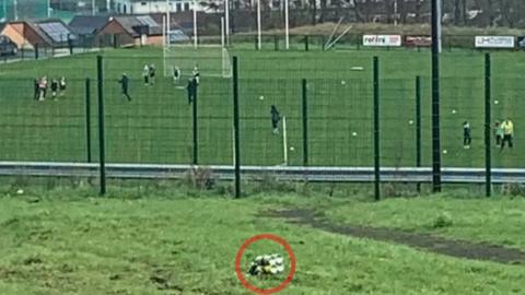 Explosive device - a silver-coloured object pictured on the ground - close to a sports pitch