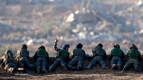 A picture taken in southern Israel near the border with the Gaza Strip on December 11, 2023, shows Israeli army soldiers keeping position on a hill overlooking northern Gaza, amid continuing battles between Israel and the militant group Hamas