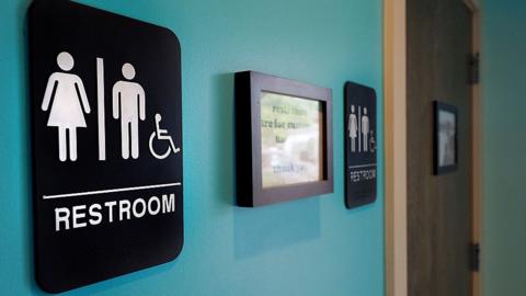 Unisex signs hang outside bathrooms at Toast Paninoteca on May 10, 2016 in Durham, North Carolina.