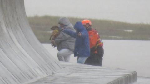 People and dog being rescued