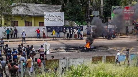 Protesters block a road and set alight tyres in Rambukkana on April 19, 2022