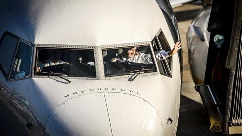 A pilot waves as a Ryanair plane arrives at Schiphol Airport in Amsterdam