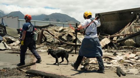 Emergency workers search through destroyed neighbourhoods in the Maui city of Lahaina, Hawaii
