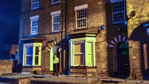 Staffordshire police officers stand guard at a property in Stafford