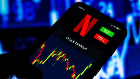 A stock trading graph of Netflix on a smartphone screen.
