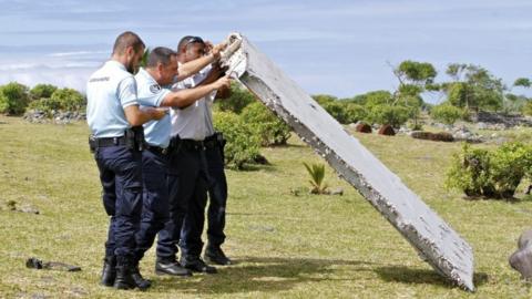 French police officers inspect the wing part in Reunion (29 July 2015)