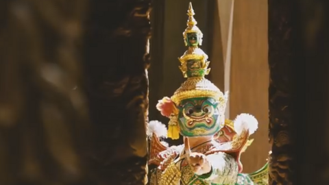 A still from the video showing one of the characters in a traditional mask