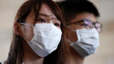 Pro-democracy activists Joshua Wong and Agnes Chow arrive at the West Kowloon Magistrates' Court in Hong Kong