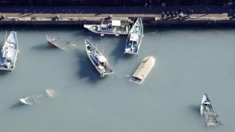 Capsized boats believed to be affected by the tsunami after an underwater volcano eruption are seen in Muroto, Kochi prefecture, Japan. Photo: 16 January 2022