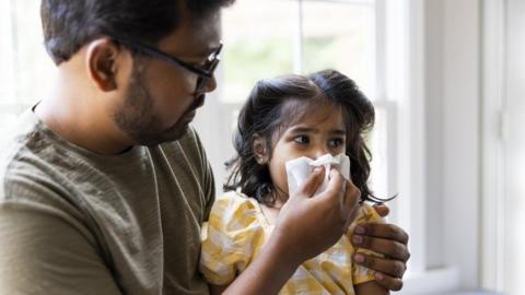 Dad blowing daughter's nose