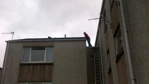 Cat being coaxed off roof in Stornoway