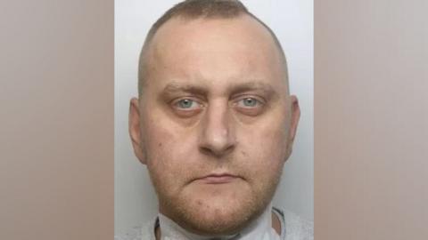 Mug shot of short-haired, round-faced man