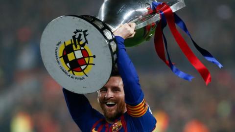 Messi holding the La Liga trophy