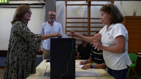 A woman casts her ballot at a polling station