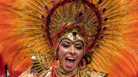 Samba performers in colourful costumes dance to the rhythms of the mobile sound systems during the grand finale (Monday Parade) of the Notting Hill Carnival in London