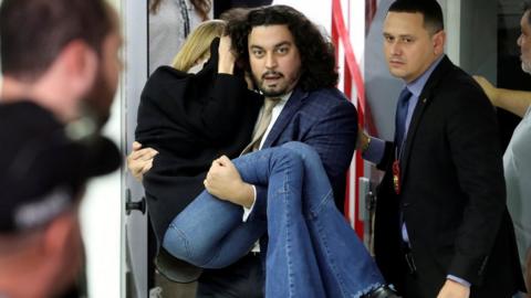 Lawyer Danilo Garcia de Andrade is pictured carrying Ms Trindade