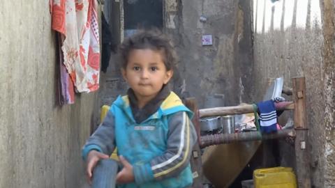 A little boy plays with a tyre in an alley in Sanaa