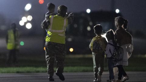 Children are guided after landing in the UK after being evacuated from Kabul
