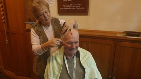Woman cutting man's hair