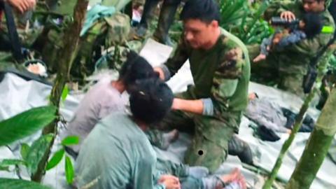 Colombian military soldiers attend to child survivors from a Cessna 206 plane that crashed in the jungles of Caqueta, in limits between Caqueta and Guaviare, 9 June 2023