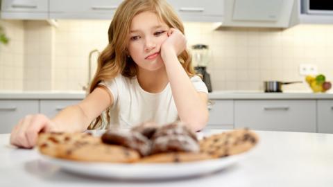 Girl looking at a plate of biscuits