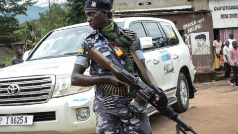 A security guard holds a gun in Kabezi, about 30km south of Bujumbura, Burundi, on May 11, 2018