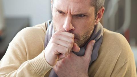 Man coughing into hand