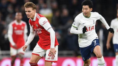 Martin Odegaard of Arsenal takes on Son Heung-Min of Tottenham.
