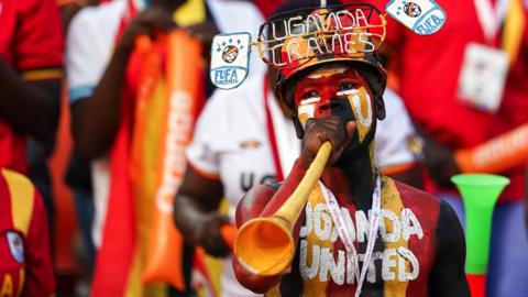 A Uganda fan blows a vuvuzela