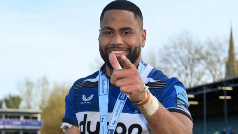 Joe Cokanasiga points to the camera wearing a player of the match medal around his neck