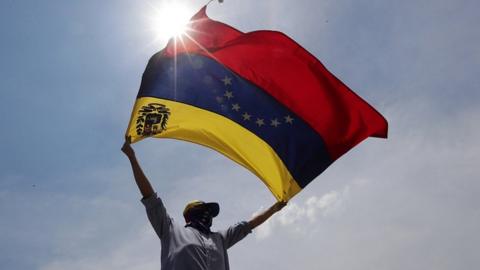 Demonstrators take part in a protest in Caracas, Venezuela, 1 May 2019