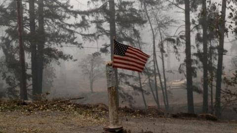 A U.S. flag is taped to the pole at the entrance of a house destroyed by fire in the aftermath of the Beachie Creek fire near Gate