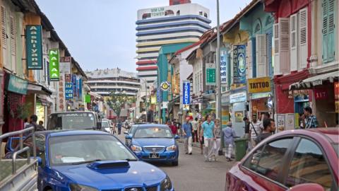 Tourists walking past colourful shops in Little India in Singapore.