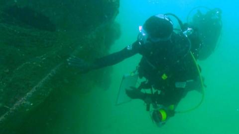 Diver examines a shipwreck