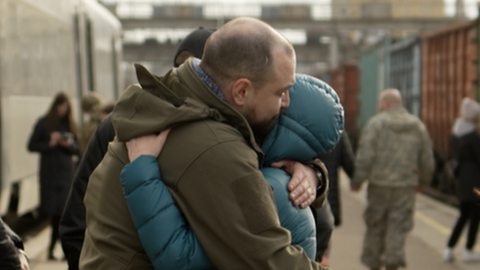 Two people hug at Kramatorsk train station