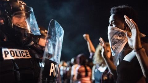 Police officers face off with protesters following the death of a man shot by a police officer in Charlotte, Nort Carolina.