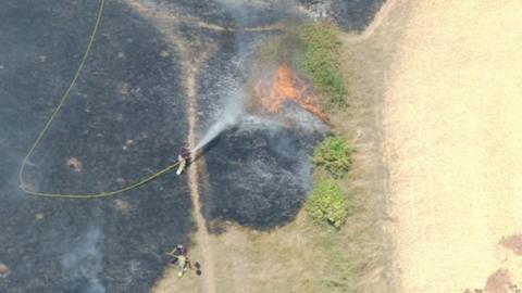 A firefighter using a hose to tackle the blaze