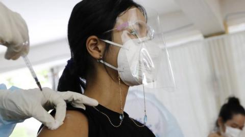 A woman is injected with a dose of Sinopharm COVID-19 vaccine during a vaccination drive held at a center in Phnom Penh, Cambodia, 28 April 2021.