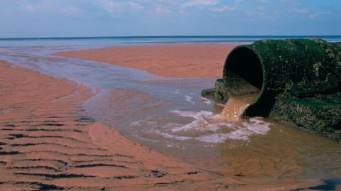 Pipe discharging sewage onto a North Sea beach at Hartlepool