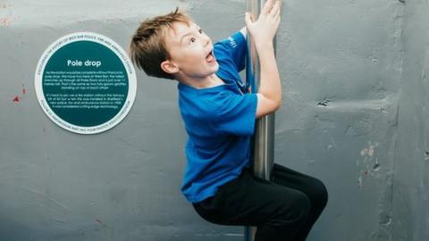 Young boys sliding down fire poles