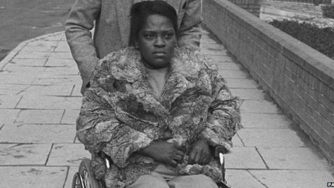Cherry Groce being pushed in a wheelchair