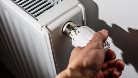 Man adjusting a radiator