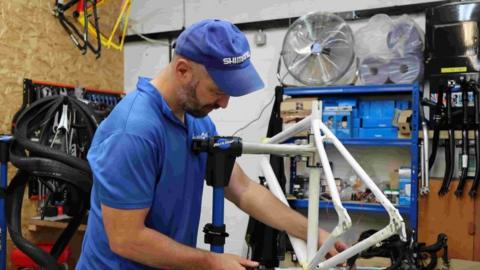 A staff member repairs a bike at the charity