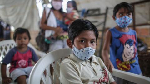 Indigenous boys wearing protective masks wait for vaccine and testing at Parque das Tribos community, on May 21 2020 in Manaus