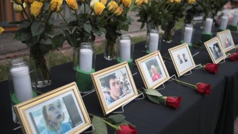 Pictures of Santa Fe school shooting victims stand by white candles and yellow roses