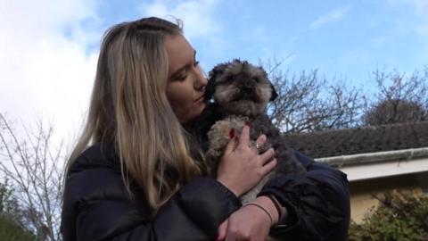 Emma hugs her dog